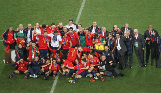 Aufstellen zum Gruppenfoto mit sämtlichen Beteiligten: Spieler, Trainer, Betreuer, alle dabei. Nur der Pokal ist gut versteckt