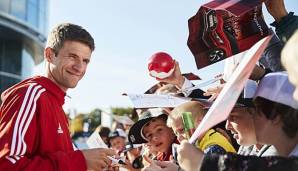 Thomas Müller schreibt bei einem Medien-Event Autogramme