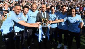 Pep Guardiola (M.) mit seinem Trainerteam und dem Meisterpokal.