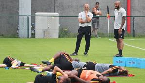 Roberto Martinez und Thierry Henry beobachten ihre Spieler beim Dehnen.