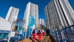 Das olympische Dorf mit den ersten Athleten auf dem Weg hinein