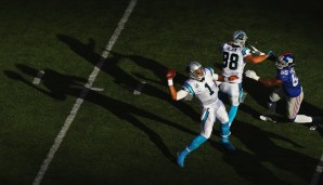 Spiel im Schatten: Newton (l.) feuert den Ball heraus, bevor der Pass Rush herankommt